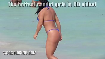 busty bimbo wears micro thong bikini on the public beach